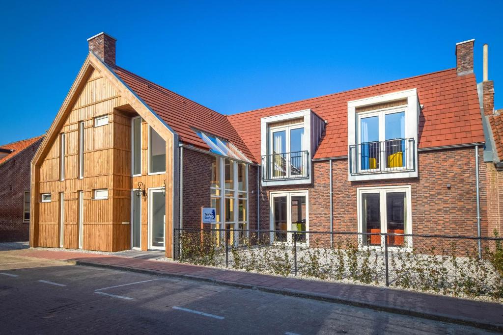 een groot bakstenen gebouw met een bruin dak bij Table d'Hôte Teune & Janna in Zoutelande