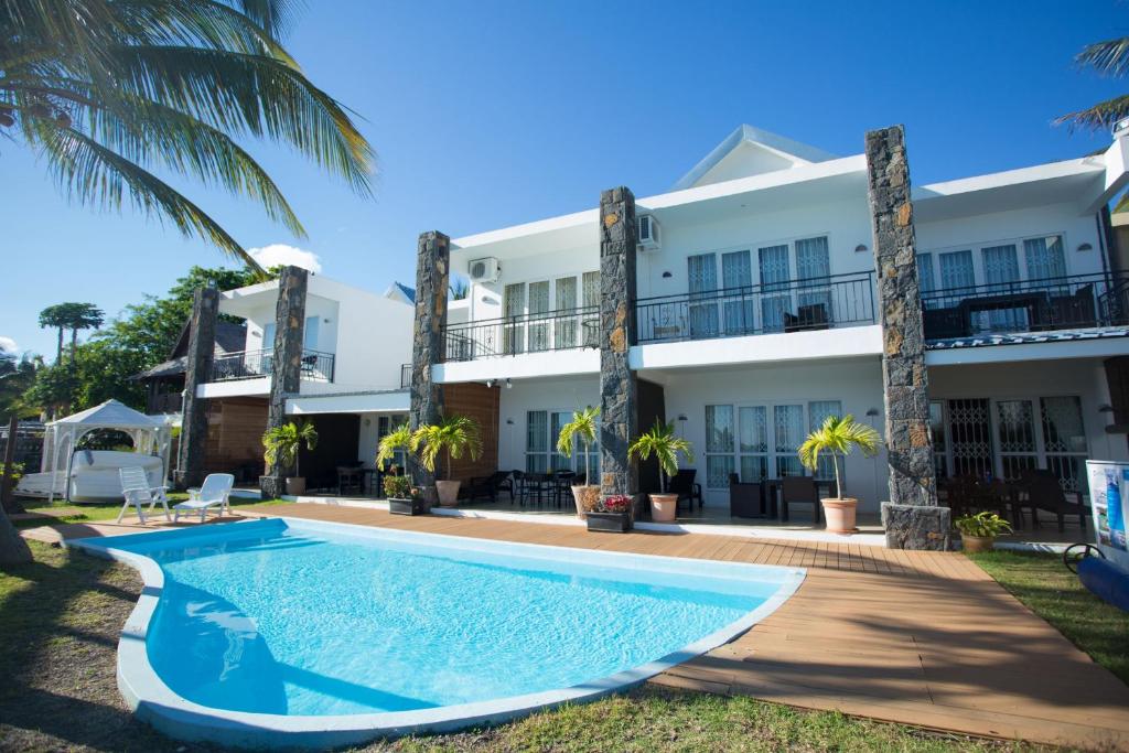 a swimming pool in front of a building at Garden Villas in Grand-Baie