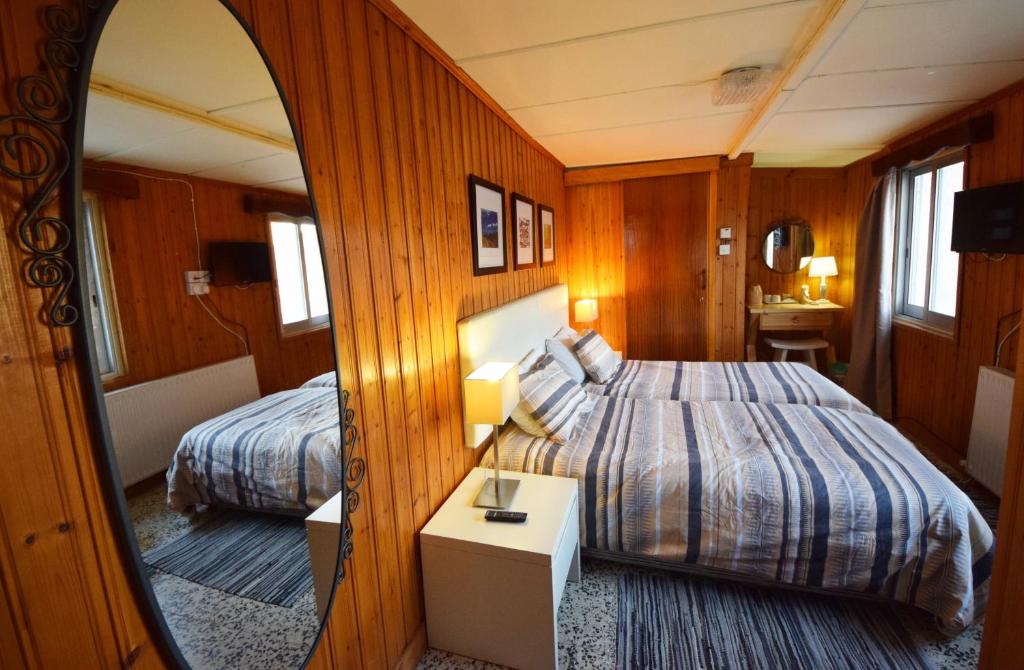 a bedroom with a bed and a mirror in a train at Christys Palace Hotel in Pedoulas