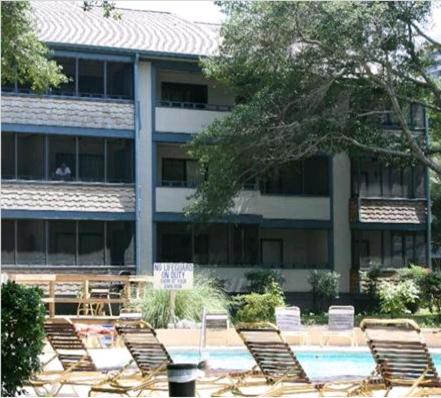 un edificio con sillas y una piscina frente a un edificio en Summer Tree Village A11, en Myrtle Beach