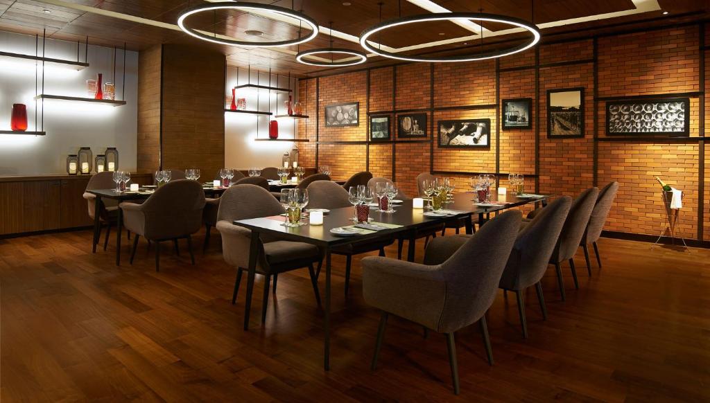 a restaurant with tables and chairs in a room at Amari Bangkok in Bangkok