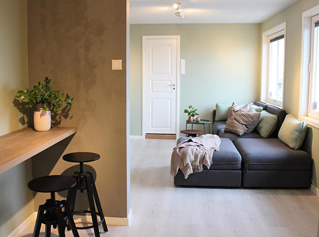 ein Wohnzimmer mit einem Sofa und 2 Barhockern in der Unterkunft City View Studio Apartment in Ålesund