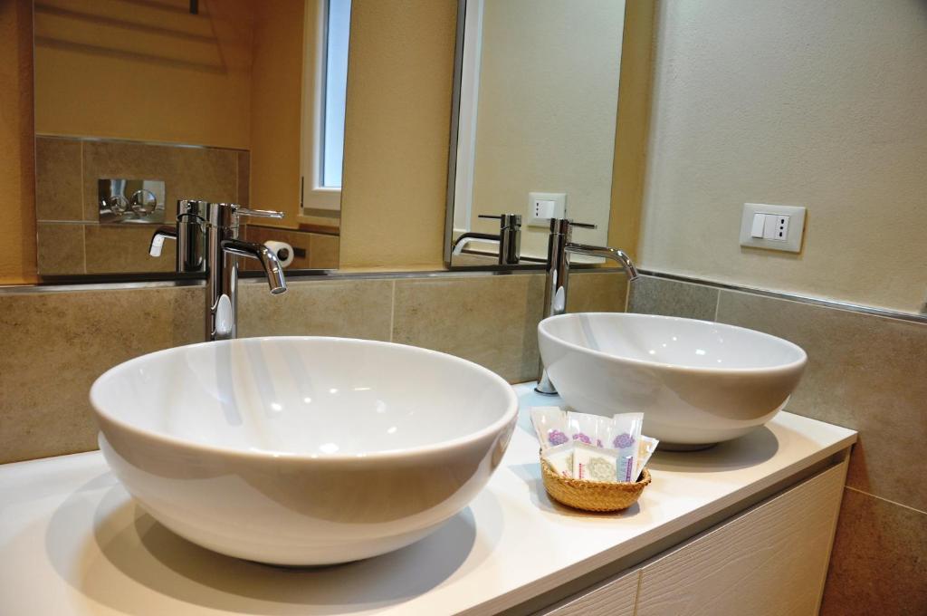 - une salle de bains avec 2 grands bols blancs sur un comptoir dans l'établissement San Guglielmo Apartments, à Ferrare