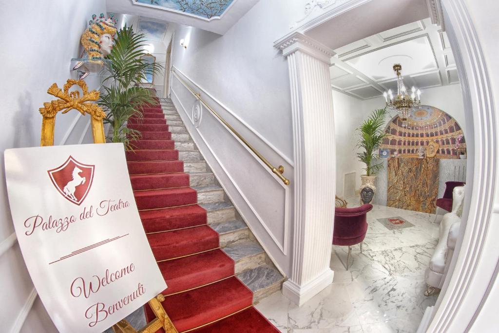 a staircase with a sign that reads queens all china boutique at B&B Palazzo del Teatro in Agrigento