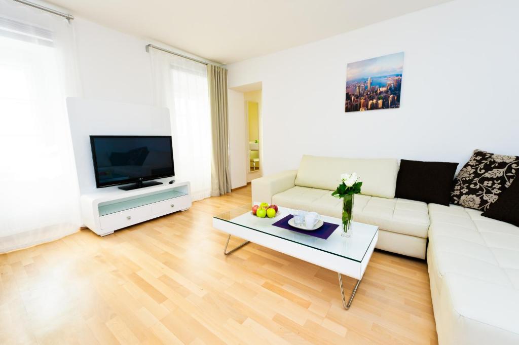 a living room with a white couch and a tv at VOX Design Hotel in Vienna