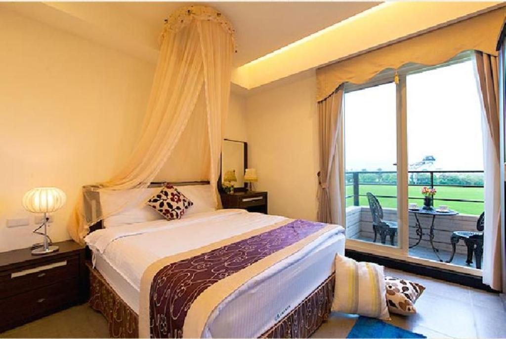 a bedroom with a bed and a large window at Rice Countryside in Dongshan