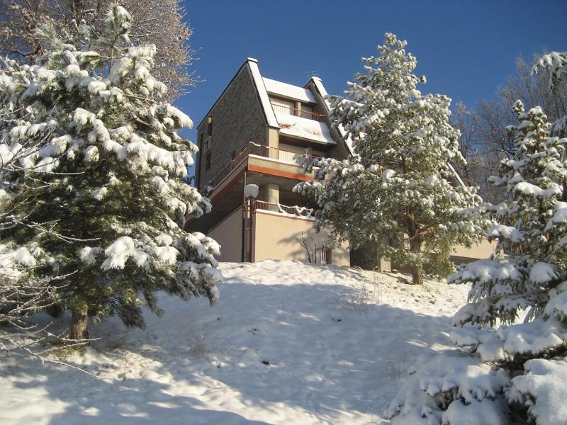 a building in the snow with trees in front of it at Villa Bellavista in Sestola