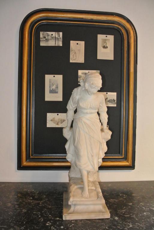 a statue of a woman standing in front of a framed picture at Chambre d&#39;hôtes Au jardin de la Bachellerie in La Bachellerie