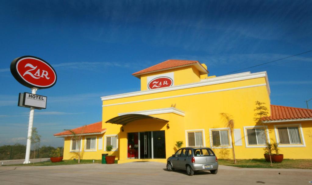 ein gelbes Gebäude mit einem davor geparkt in der Unterkunft Zar Culiacan in Culiacán Rosales