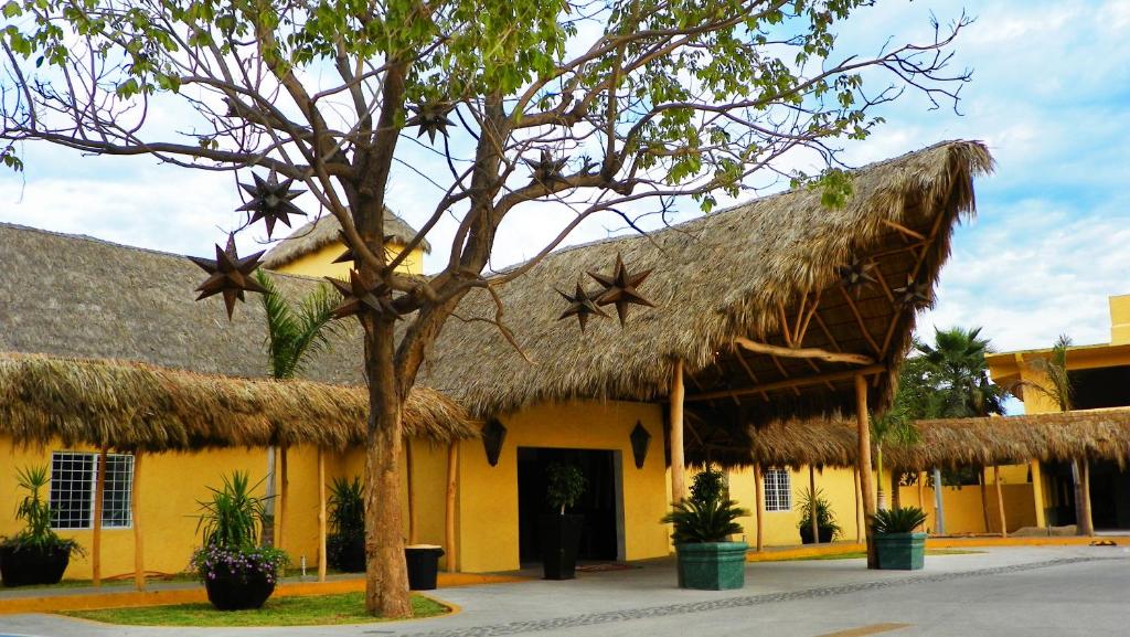 a building with a straw roof with stars on it at Zar Manzanillo in Manzanillo