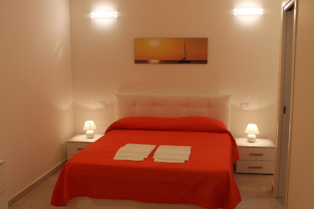 シラクーサにあるLa Rosa dei Ventiのベッドルーム1室(赤いベッド1台、白いタオル2枚付)
