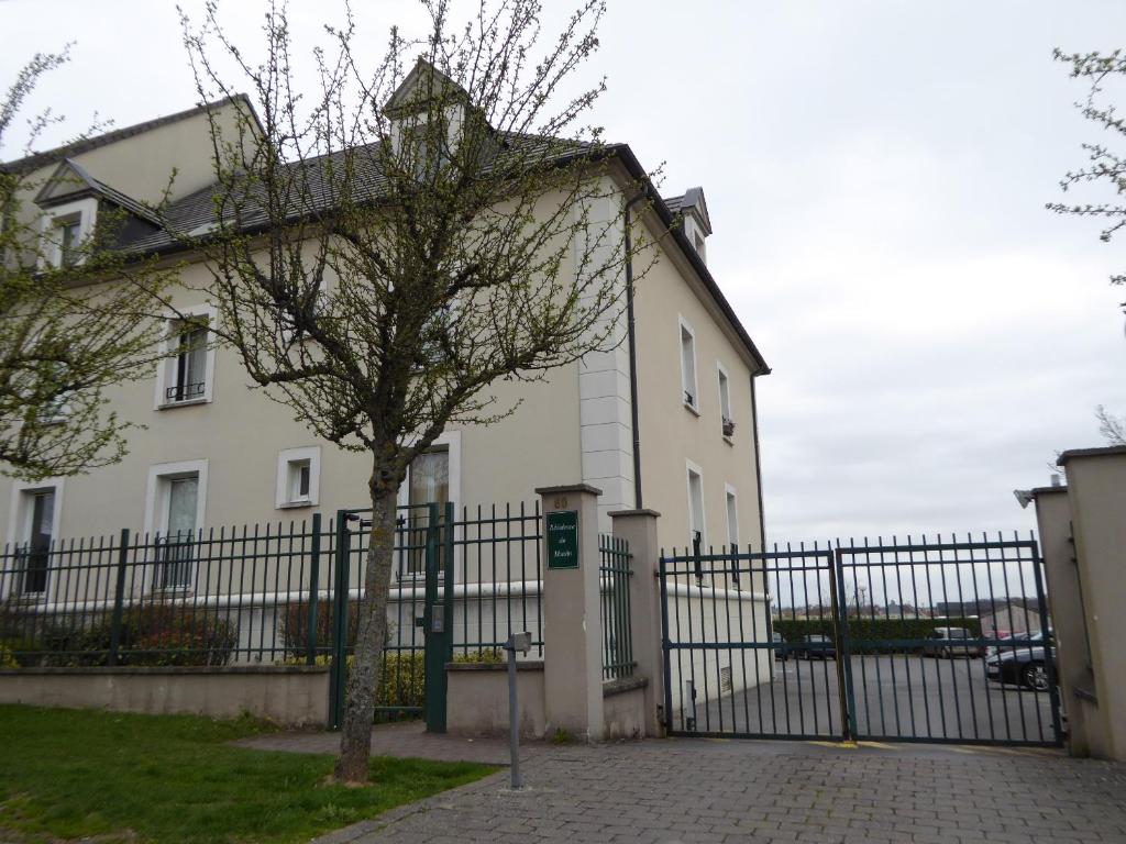 a white house with a fence and a tree at Appartement 5min to DisneyLand, parking privé in Magny-le-Hongre