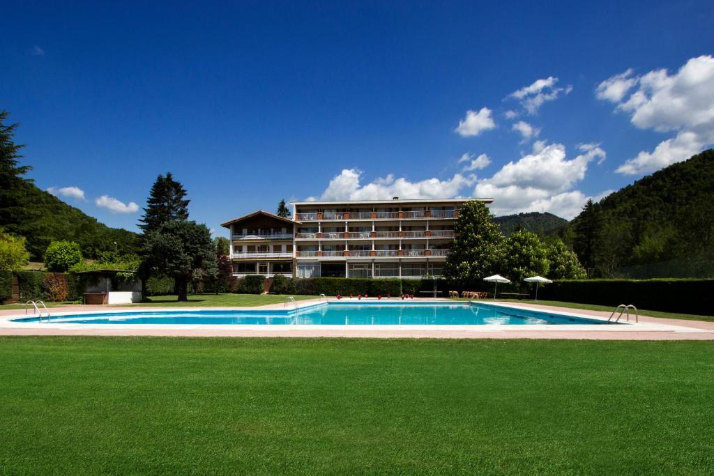 un hotel con piscina frente a un edificio en Hotel Solana del Ter, en Ripoll