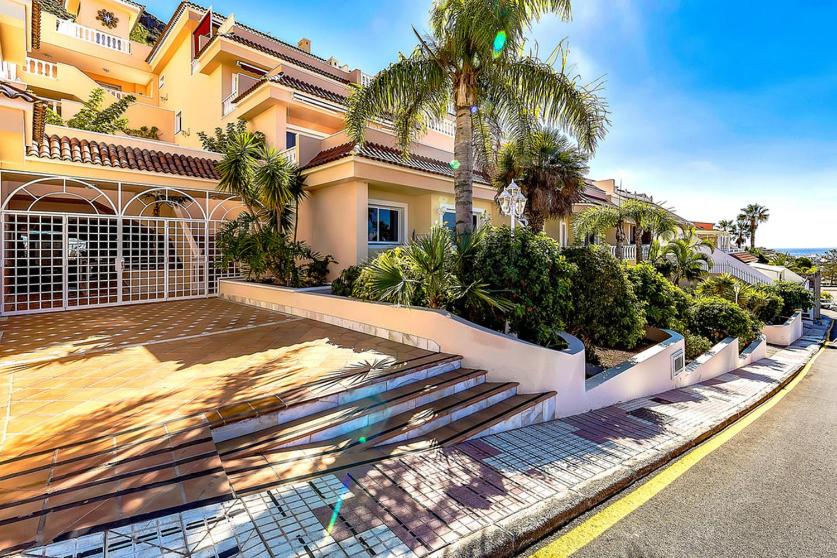 un edificio con escaleras y palmeras junto a una calle en Wonderful apartment in Los Gigantes Buena Vista, en Acantilado de los Gigantes