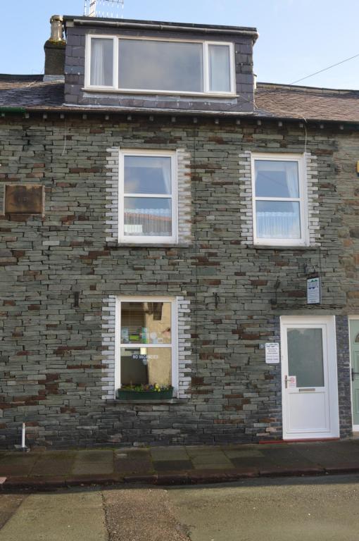 ceglany dom z dwoma oknami i drzwiami w obiekcie Beckside Guest House Keswick w mieście Keswick