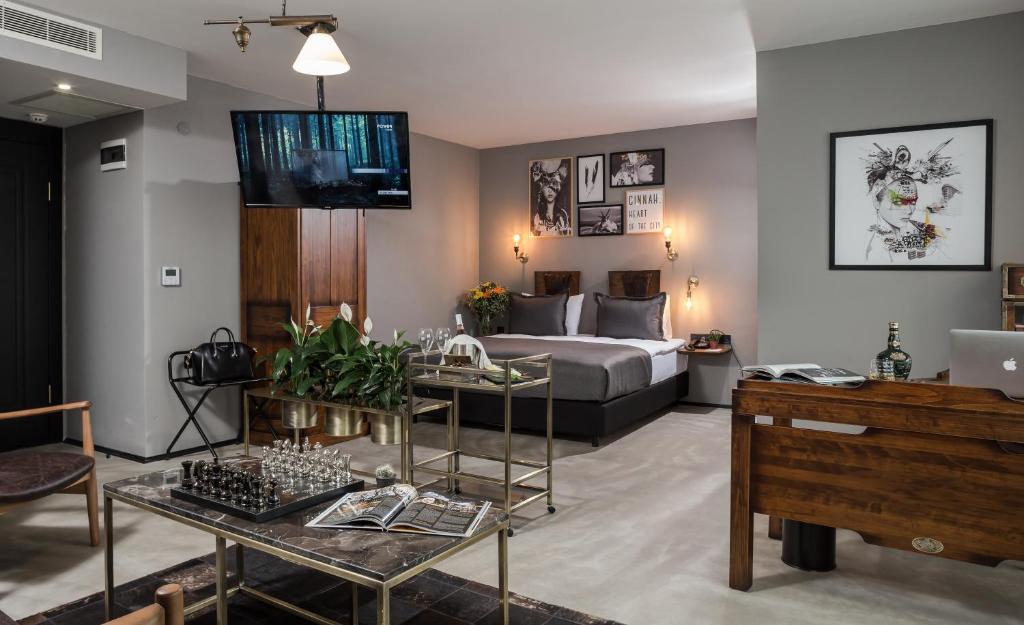 uma sala de estar com uma cama e um sofá em Hotel Cinnah em Ancara