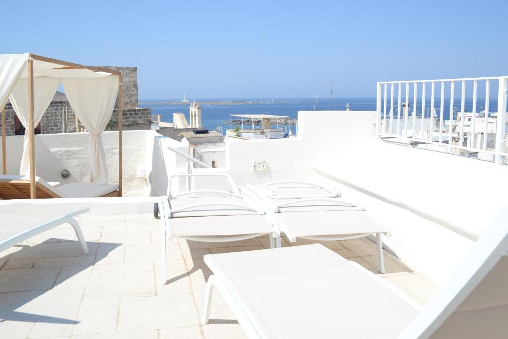 a row of white tables and chairs on a balcony at Domus Dejana in Gallipoli