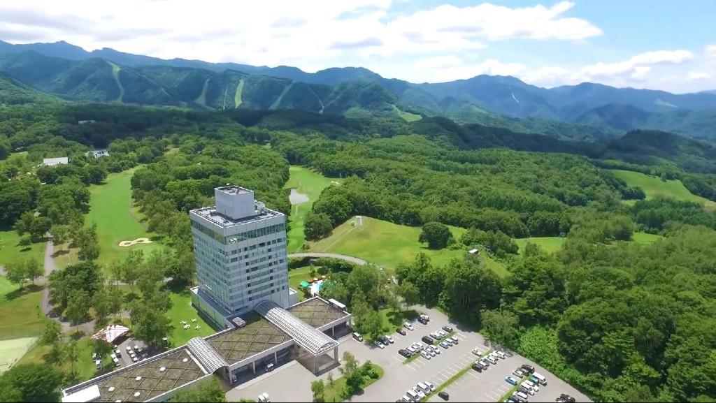 an aerial view of a building with mountains in the background at Minakami Kogen Hotel 200 in Minakami