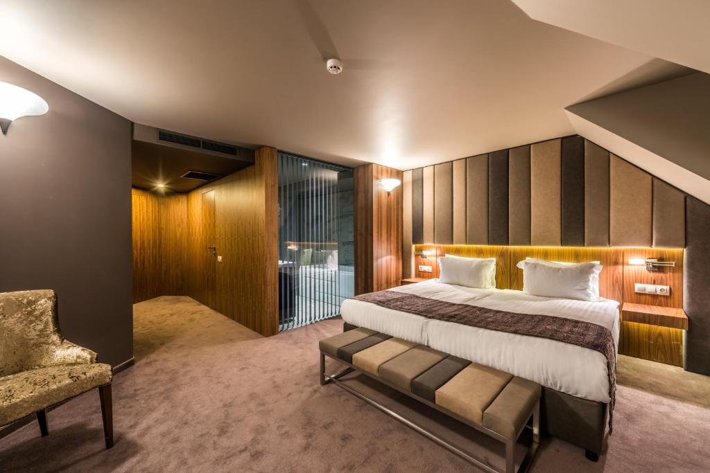 a bedroom with a large bed and a large window at All Seasons Residence Hotel in Sofia