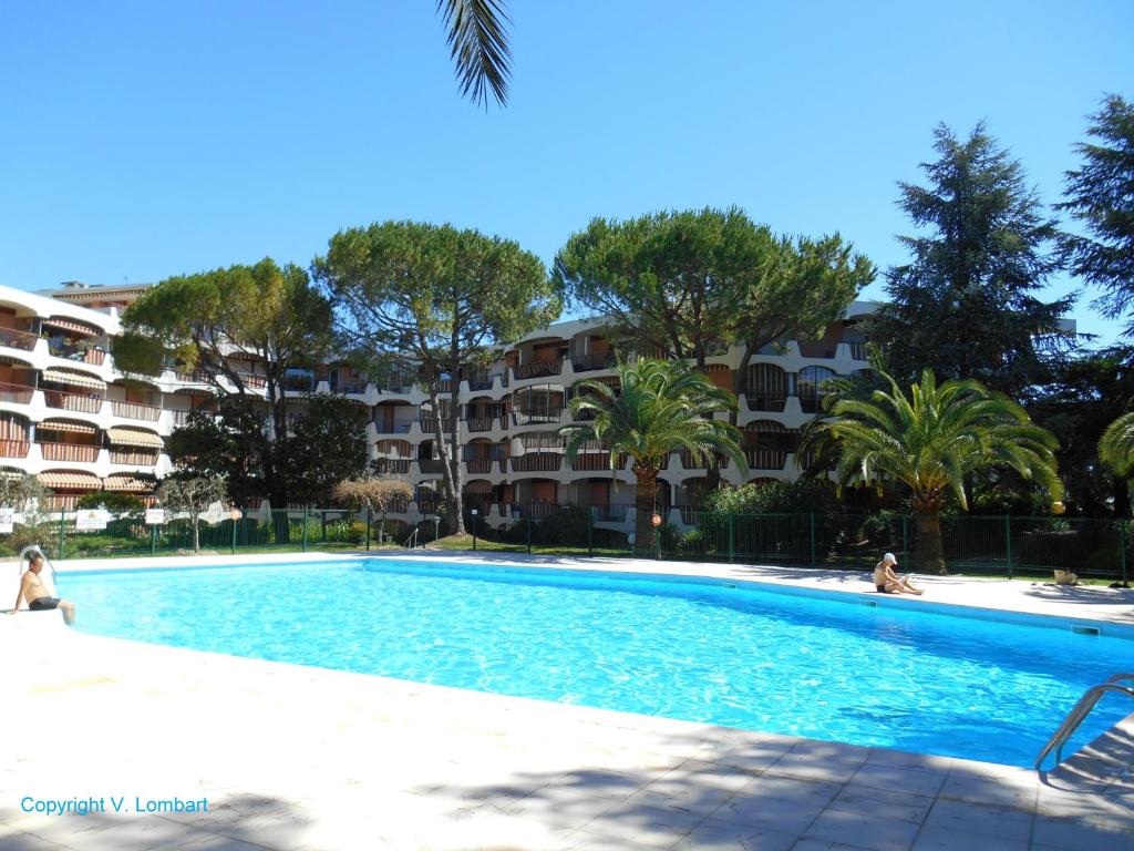 une piscine en face d'un complexe d'appartements dans l'établissement 3 Rivieres - Parc Riviera C 6, à Mandelieu-la-Napoule