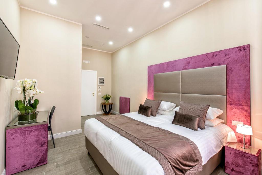 羅馬的住宿－拉格里非布魯姆公寓旅館，一间卧室配有一张大床和紫色床头板