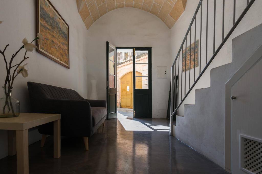 a living room with a couch and a stairway at Curniola in Ciutadella