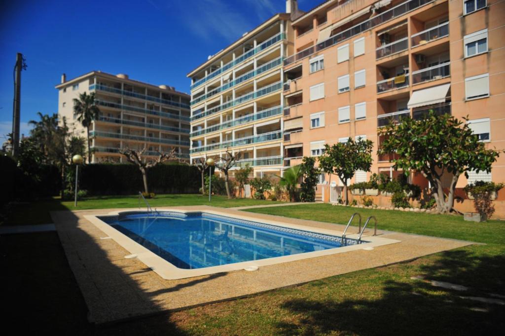 a swimming pool in front of a building at Cambrils Puerto in Cambrils