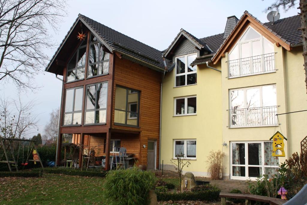 een huis met houten zijkanten en ramen bij Ferienwohnung am Riesenfuss in Pirna