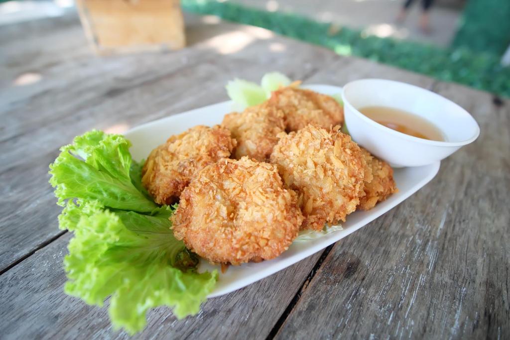 a plate of food with chicken tenders and dipping sauce at Vimarn Samed Resort in Ko Samed
