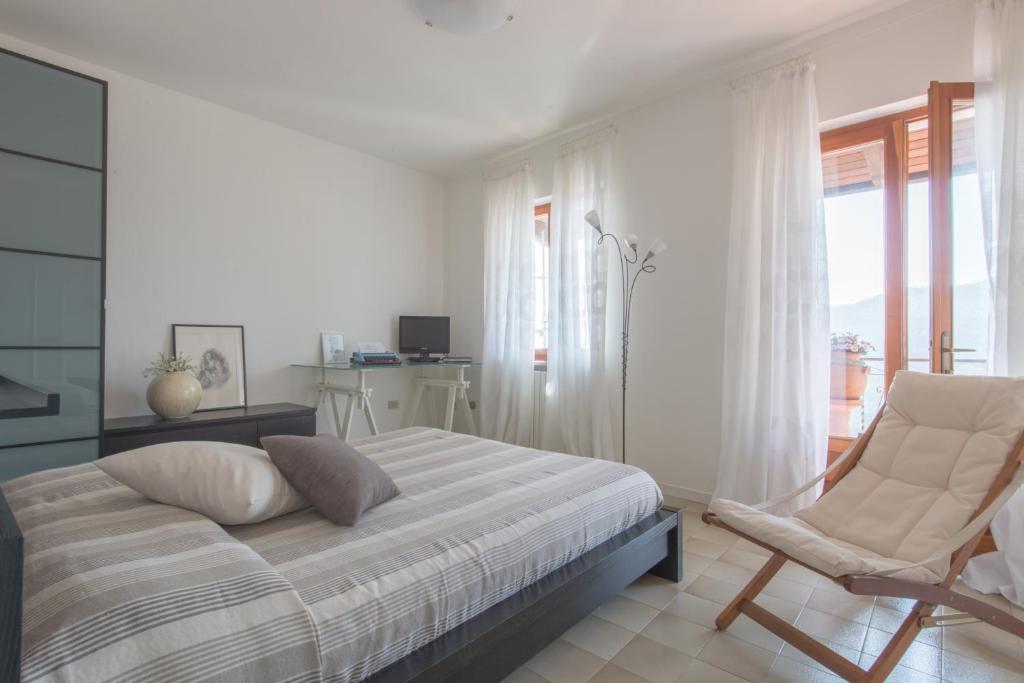 1 dormitorio con 1 cama, 1 silla y 1 ventana en Casa Maria, en Tremosine Sul Garda