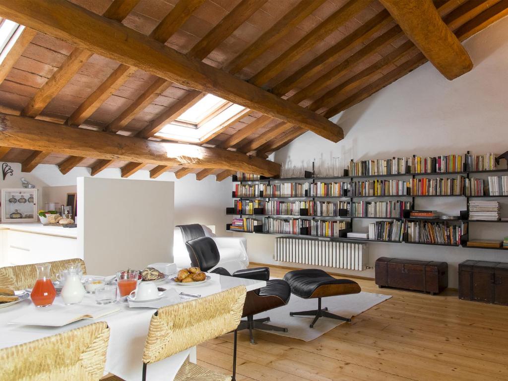 sala de estar con mesa, sillas y estante para libros en Stella21 BedandBreakfast en Modena