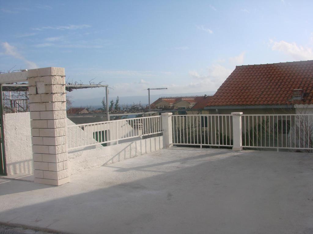 a white fence on top of a house at Apartman Restović in Bol