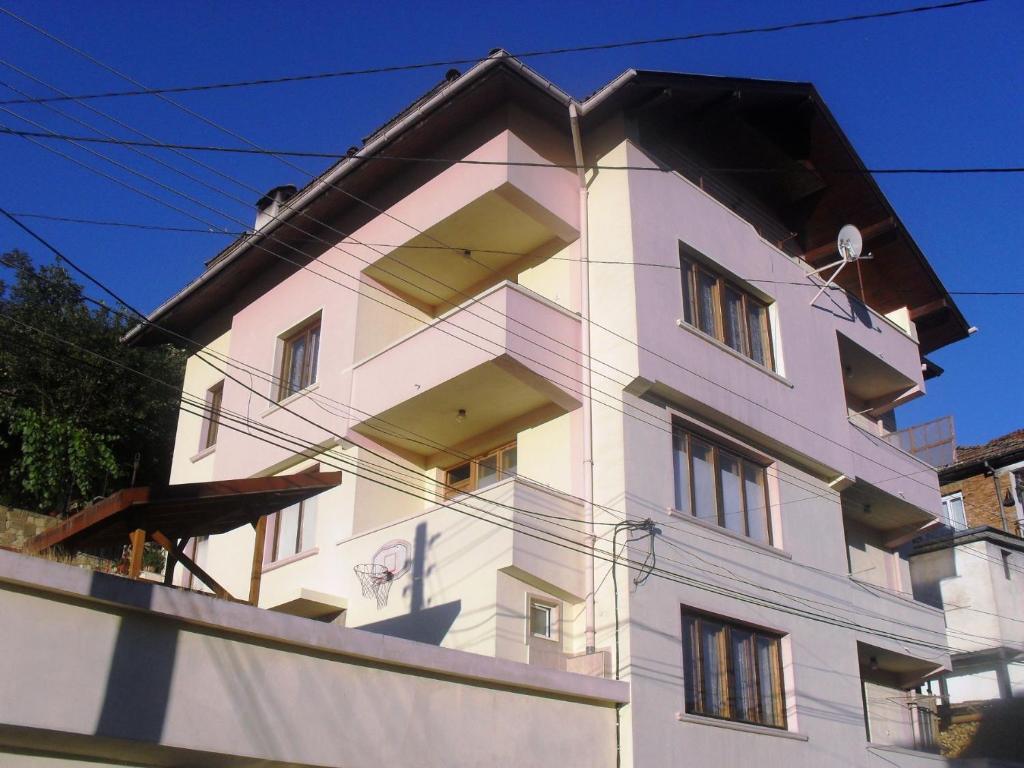 Vitosha Guest House في ديفين: مبنى أبيض مع الكثير من النوافذ