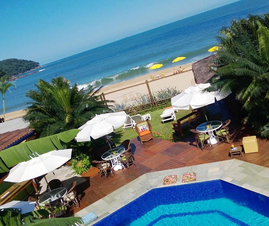 a view of a swimming pool and the beach at Pousada DiMari in Boicucanga