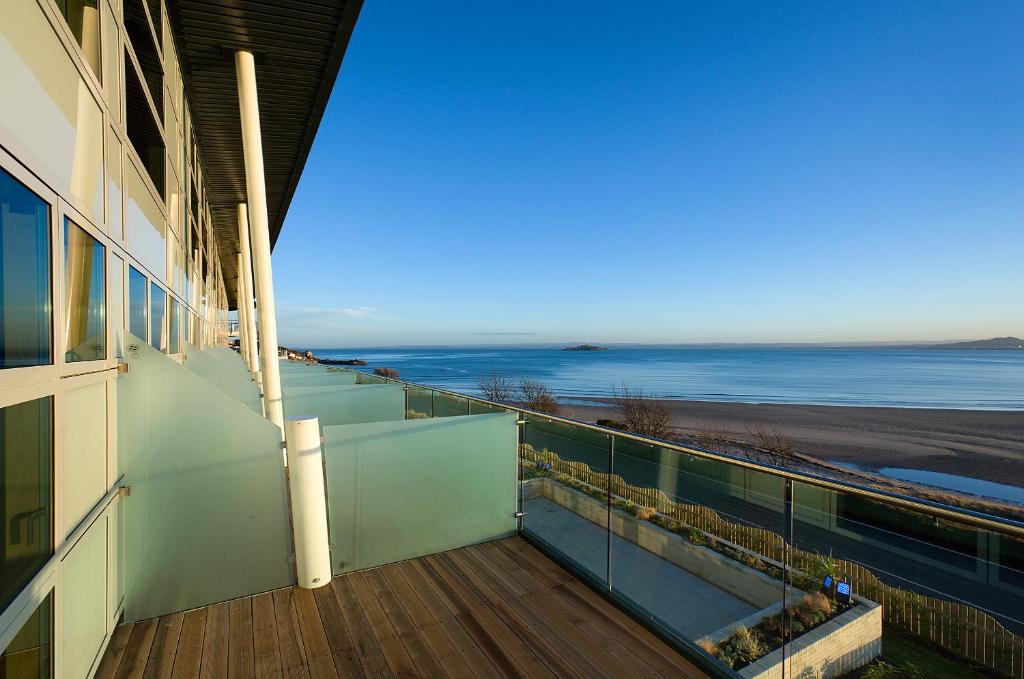 a balcony of a building with a view of the ocean at The Bay Hotel in Kinghorn