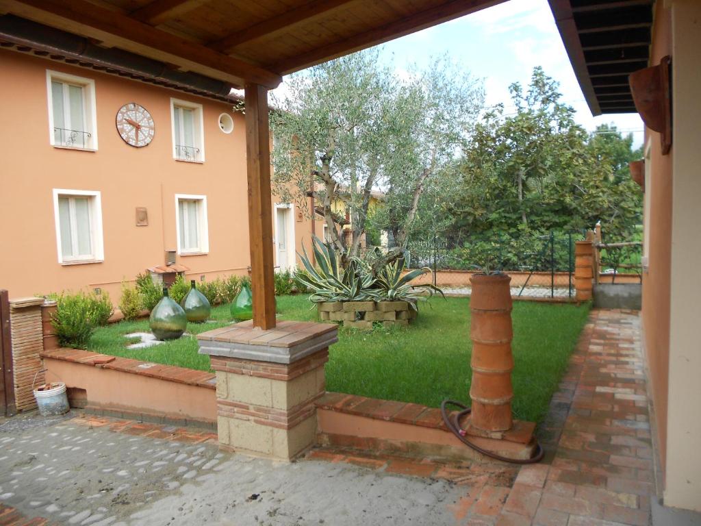 einen Hinterhof mit einem Haus und einem Garten mit einem Hof in der Unterkunft Ulivo Della Querce in Querce