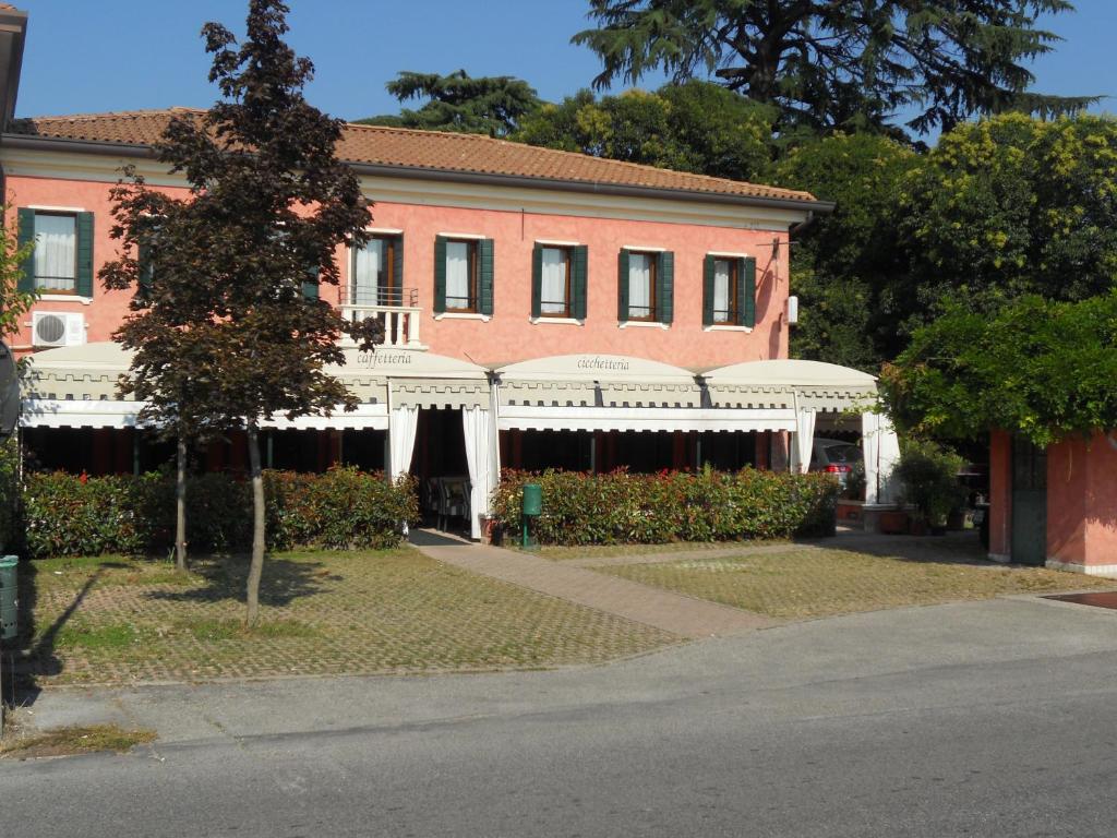 ein großes rotes Backsteingebäude mit einer weißen Markise in der Unterkunft Osteria La Pesa in Ponzano Veneto