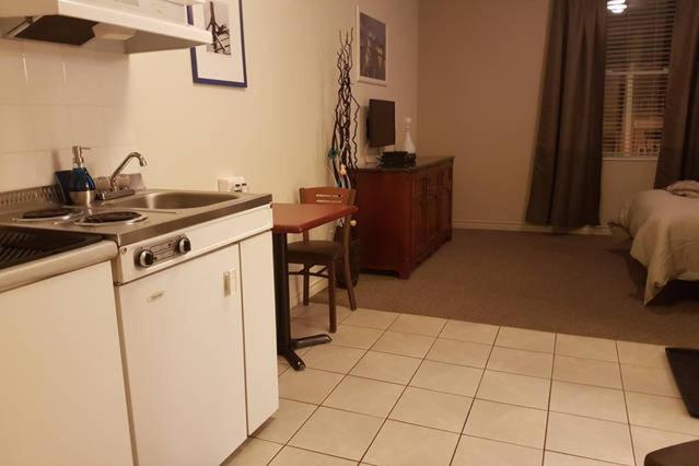 een keuken met een wastafel en een tafel in een kamer bij Cozy Little Studio #16 by Amazing Property Rentals in Gatineau