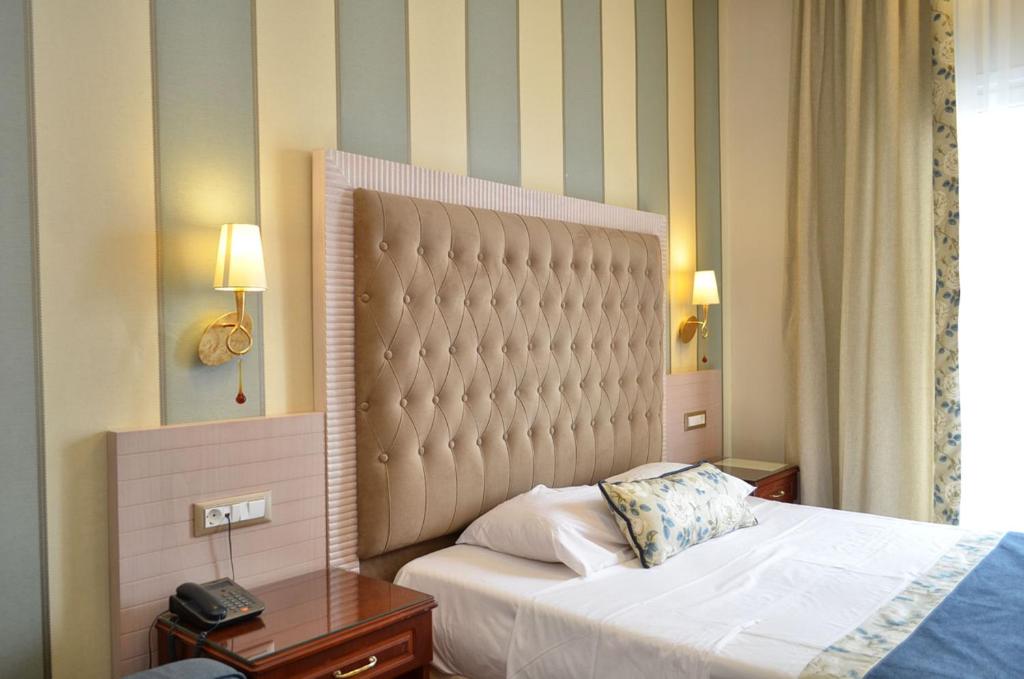 Postel nebo postele na pokoji v ubytování Olympic Hotel