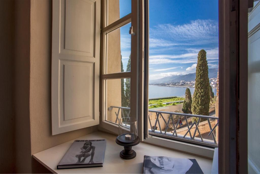 an open window with a view of the ocean at U Palazzu Ghejenuvese in Bastia