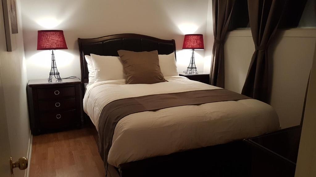 a bedroom with a large bed with two lamps at Three-Bedroom Apartment Sweet #6 by Amazing Property Rentals in Gatineau