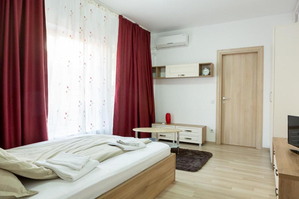 - une chambre avec un lit et un rideau rouge dans l'établissement Garsoniere Dinu, à Bucarest