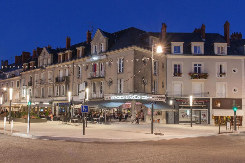 un grand bâtiment situé dans une rue de la ville la nuit dans l'établissement Le Pavillon, à Blois