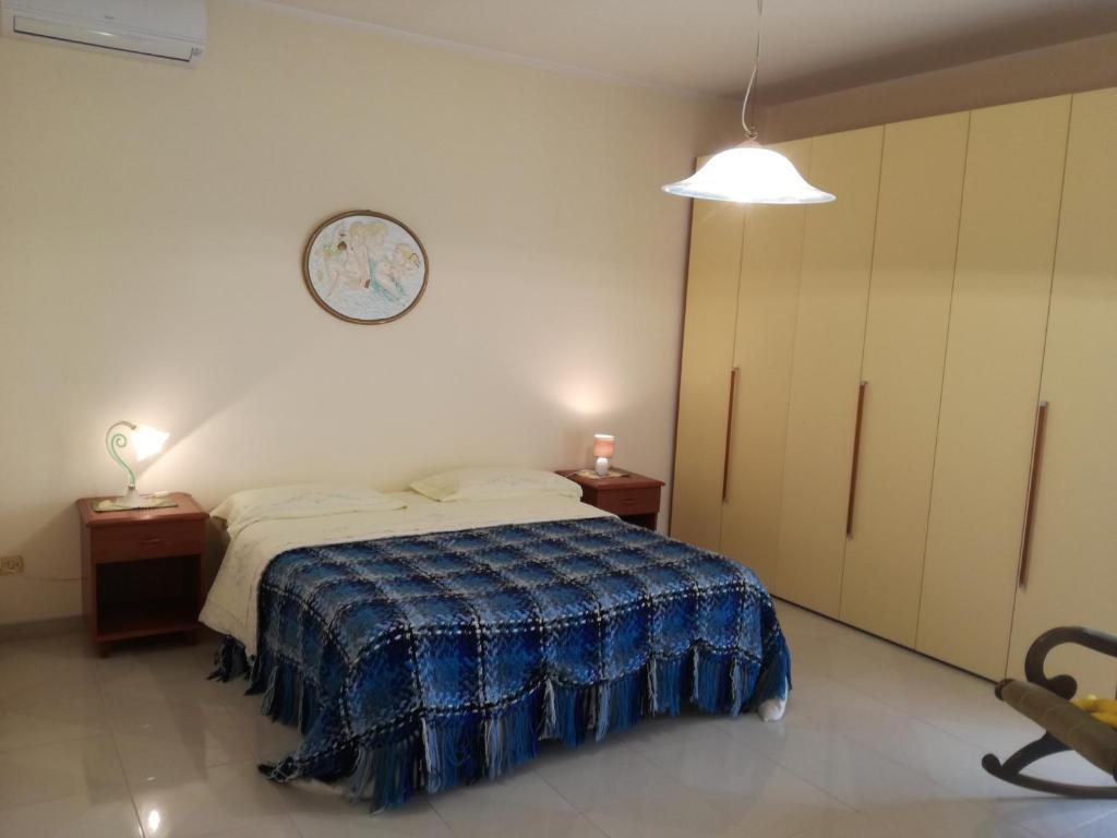 een slaapkamer met een bed en een klok aan de muur bij Appartamento in villa Virginia in Mondragone