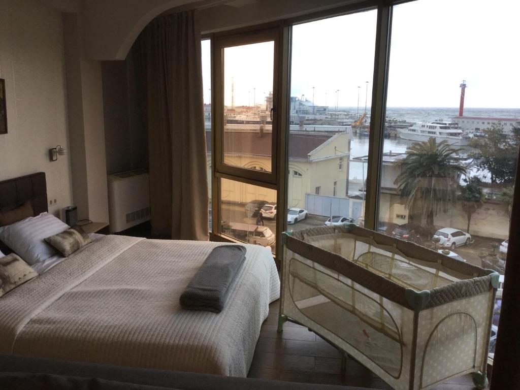 um quarto com uma cama e uma grande janela em Apartments on Nesebrskaya 14 em Sochi