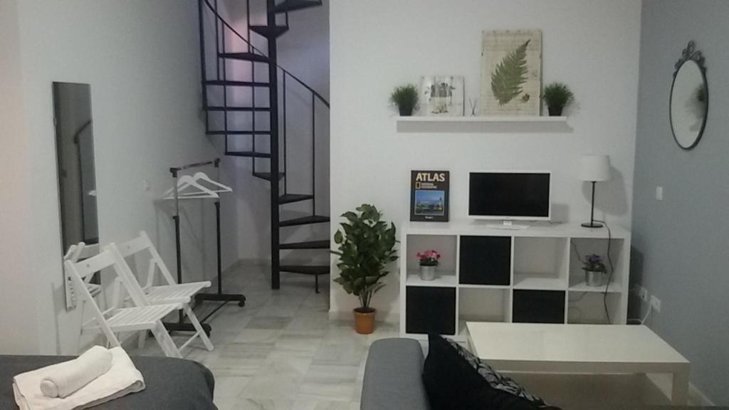 a living room filled with furniture and a tv at Apartamentos Calle Eduardo Ocón in Málaga