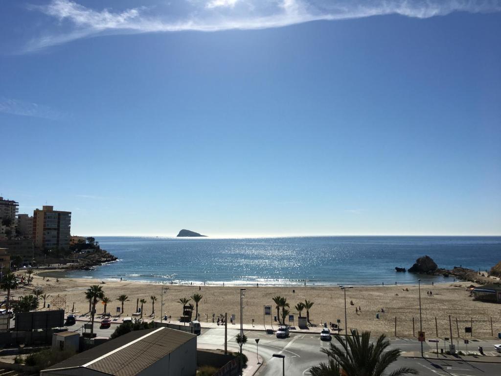 a view of a beach with palm trees and the ocean at Apartamentos Odysea By Apartamentos Valentia in Cala de Finestrat