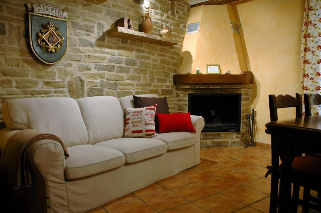 a living room with a white couch and a fireplace at Casa Rural Nuri de Rei A y B in Todolella