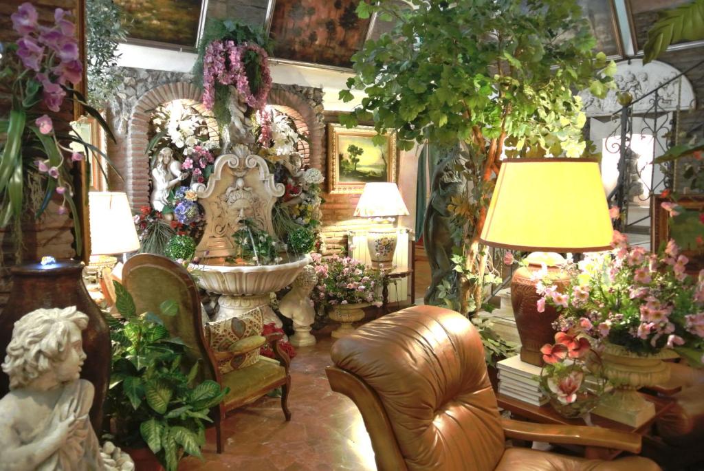 ローマにあるHotel Barrettのたくさんの花と家具が飾られたリビングルーム