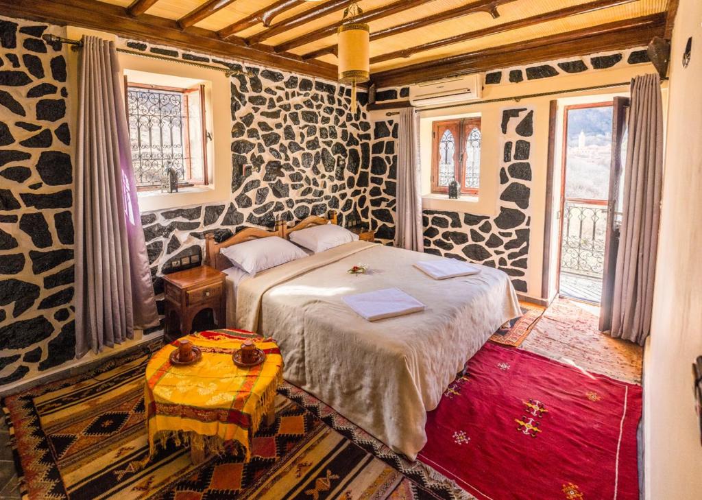 a bedroom with a bed and a table in a room at Riad Atlas 4 Seasons in Imlil